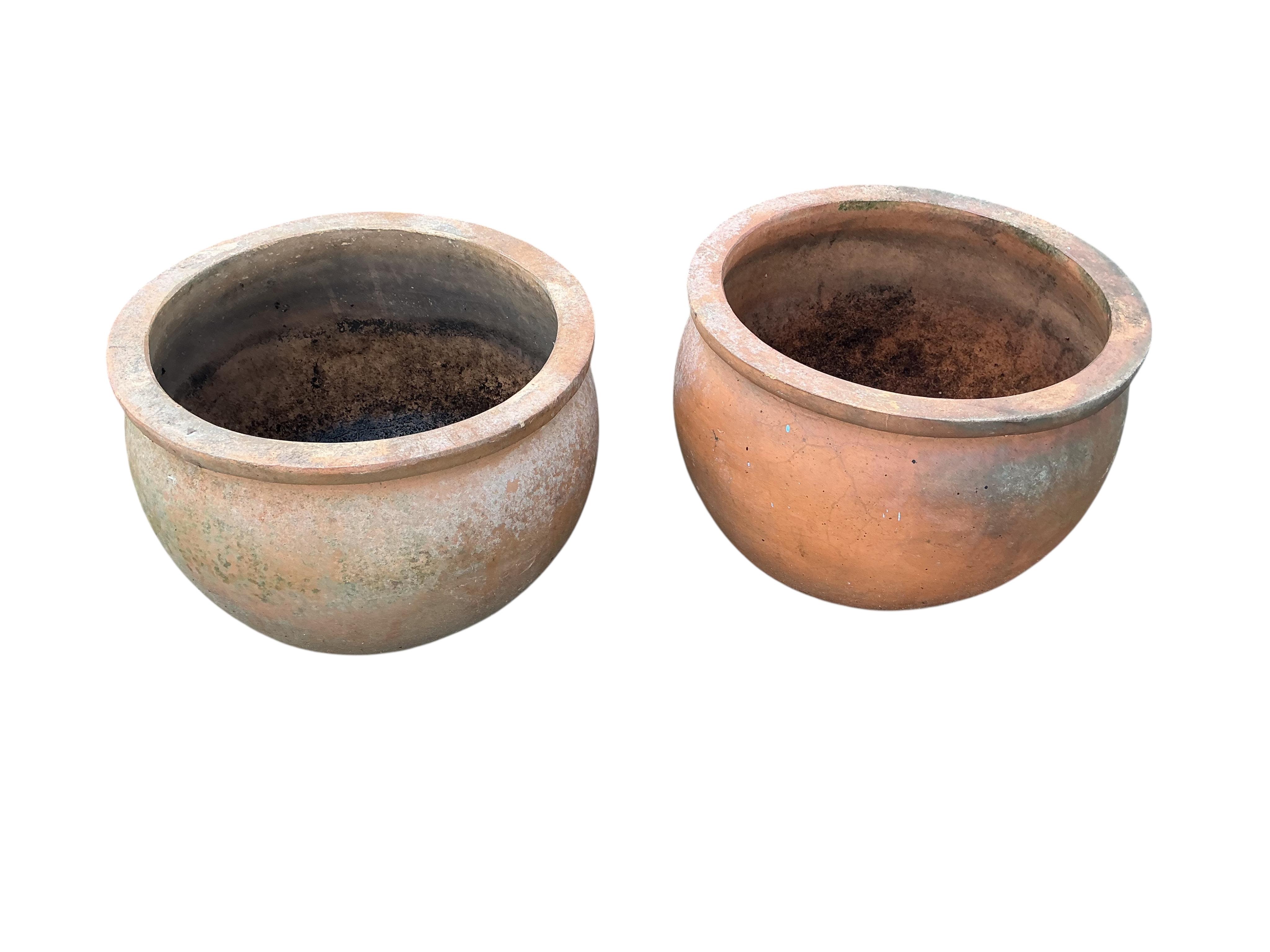 Two pairs of circular terracotta garden planters, larger diameter 40cm
